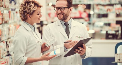 Beautiful pharmacists are checking medicine, taking notes and smiling while working in pharmacy
