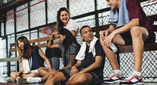Group of young teenager friends sitting on a bench relaxing